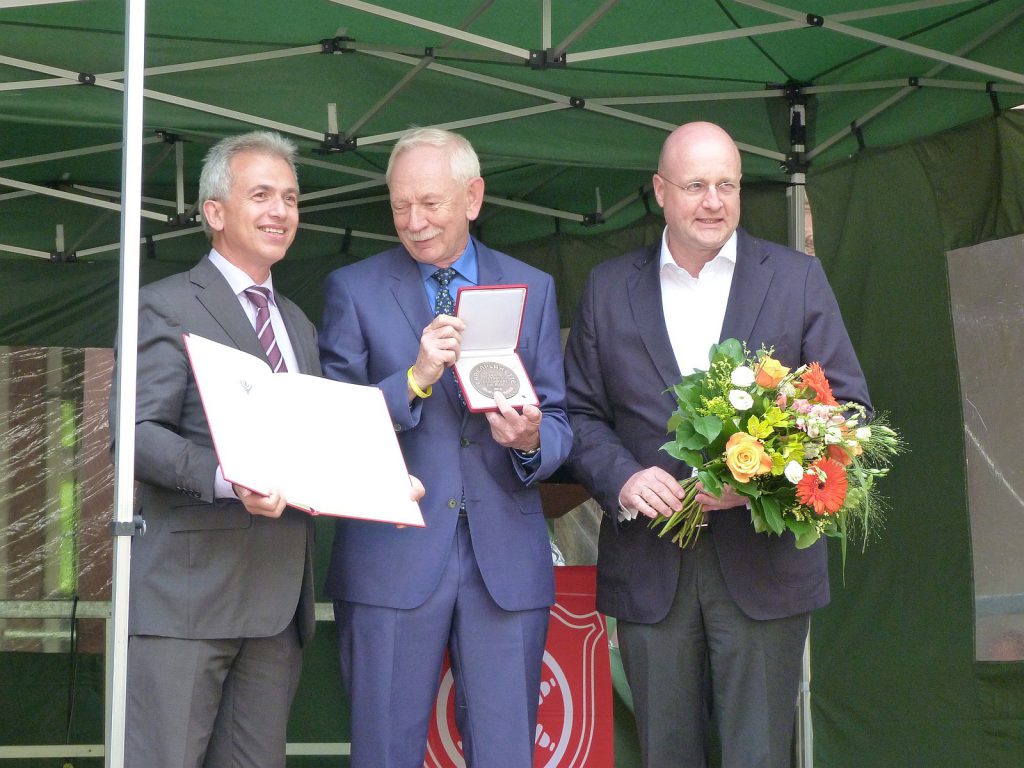 Oberbürgermeister Peter Feldmann, Ernst-Josef Robiné mit Ehrenplakette und Gratulant Jürgen Vormann