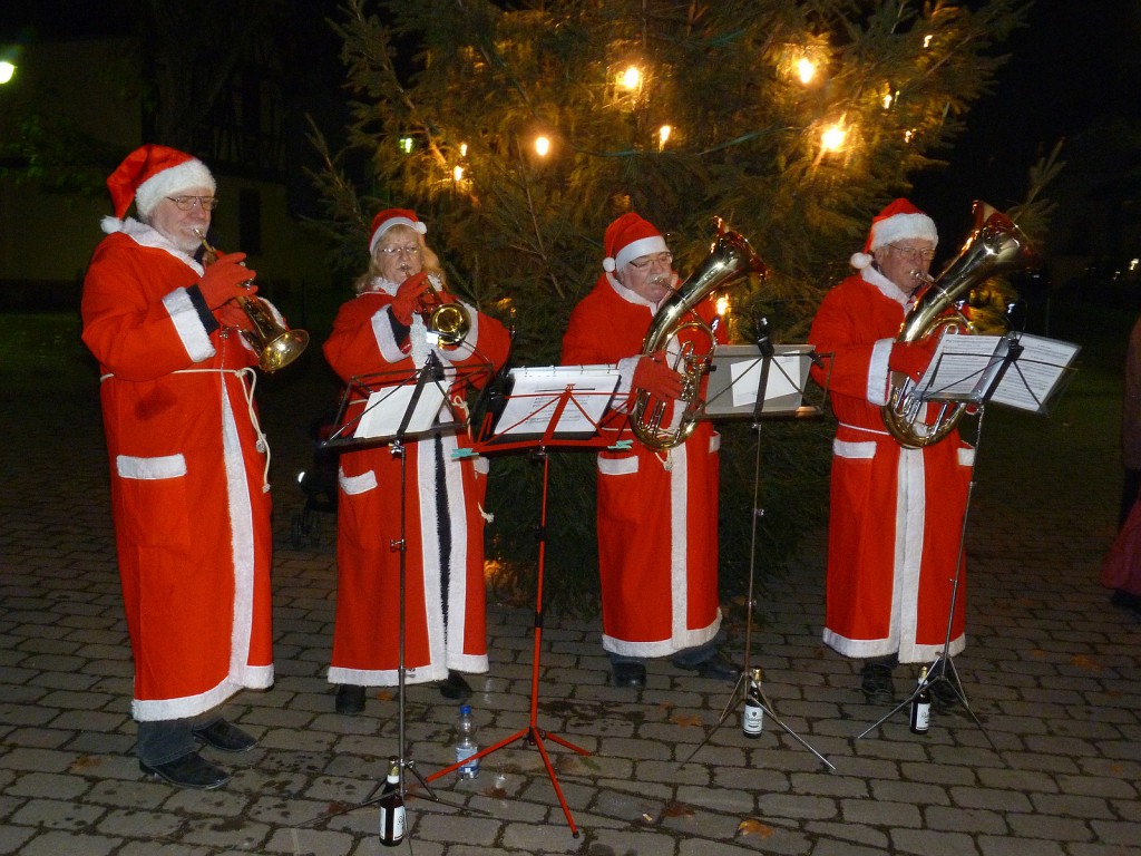 Der Weihnachtsbaum wird aufgestellt, Mitglieder des Blasochesters Höchst untermalen das kleine Fest mit weihnachtlicher Musik.