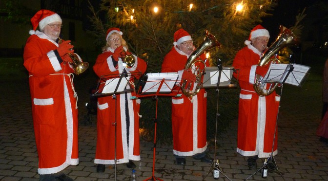 Der Weihnachtsbaum wird aufgestellt, Mitglieder des Blasochesters Höchst untermalen das kleine Fest mit weihnachtlicher Musik.