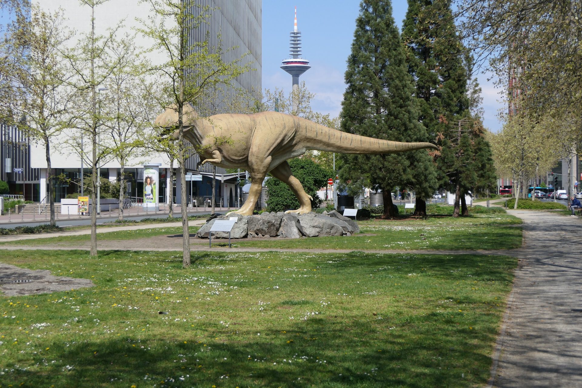 Paläobiologischer Lehrpfad in der Senckenberganlage mit Juridicum und Fernmeldeturm im Hintergrund.